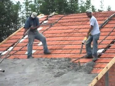 Concreto sendo espalhado sobre laje com lajotas cerâmicas